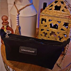 Like new Longchamp small toiletry bag w/ silver hardware and black zip closure.